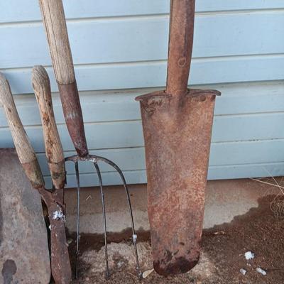 Two antique shovels with wood handles an old pitchfork and some trimmers