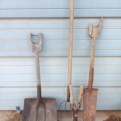 Two antique shovels with wood handles an old pitchfork and some trimmers
