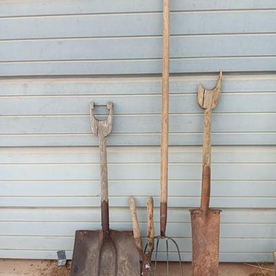 Two antique shovels with wood handles an old pitchfork and some trimmers