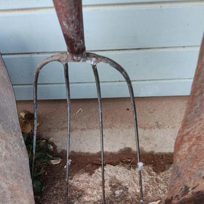 Two antique shovels with wood handles an old pitchfork and some trimmers