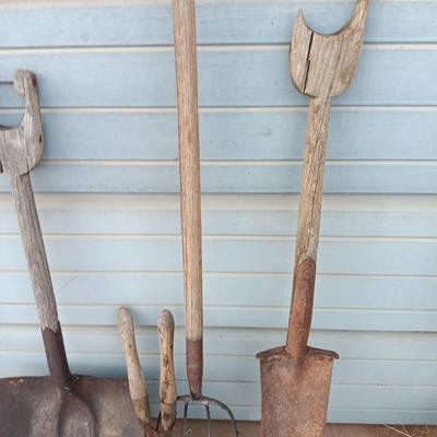 Two antique shovels with wood handles an old pitchfork and some trimmers
