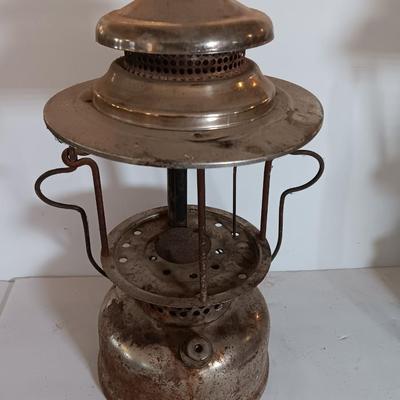 two vintage lanterns for repair with a metal container of camp fuel