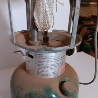 two vintage lanterns for repair with a metal container of camp fuel
