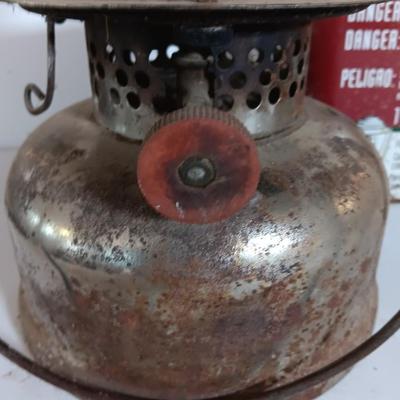 two vintage lanterns for repair with a metal container of camp fuel