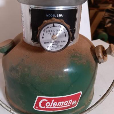 two vintage lanterns for repair with a metal container of camp fuel