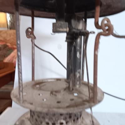 two vintage lanterns for repair with a metal container of camp fuel