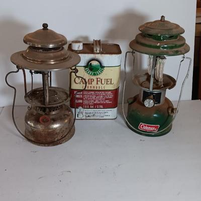 two vintage lanterns for repair with a metal container of camp fuel