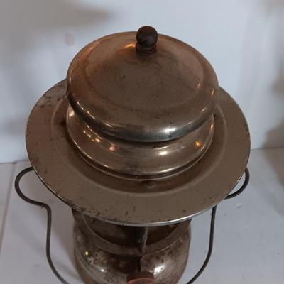 two vintage lanterns for repair with a metal container of camp fuel