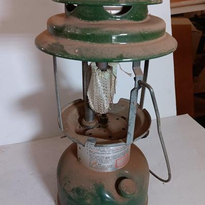 two vintage lanterns for repair with a metal container of camp fuel