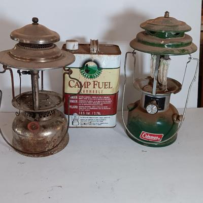 two vintage lanterns for repair with a metal container of camp fuel