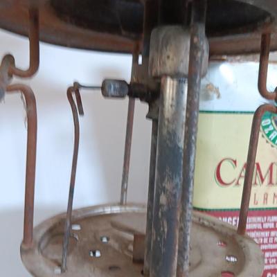 two vintage lanterns for repair with a metal container of camp fuel