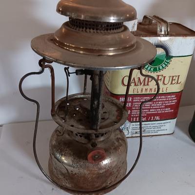 two vintage lanterns for repair with a metal container of camp fuel