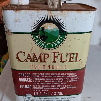 two vintage lanterns for repair with a metal container of camp fuel