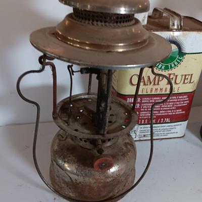 two vintage lanterns for repair with a metal container of camp fuel