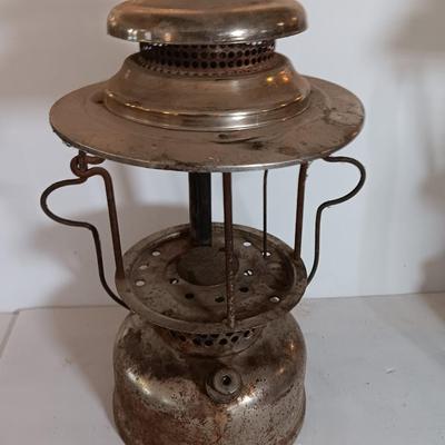two vintage lanterns for repair with a metal container of camp fuel