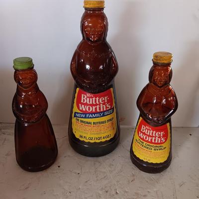 Three different sized Mrs. Butterworths bottles
