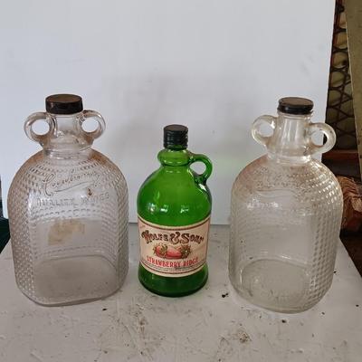 Three glass jugs with handles embossed glass design on two