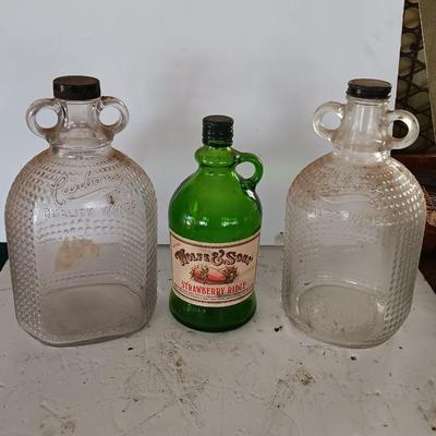 Three glass jugs with handles embossed glass design on two
