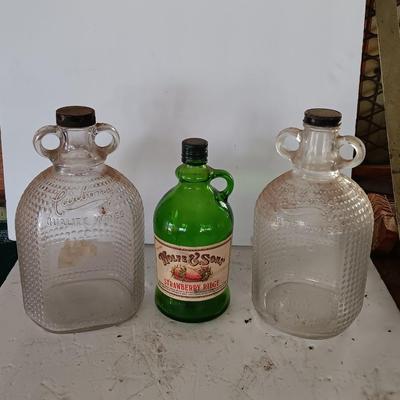 Three glass jugs with handles embossed glass design on two