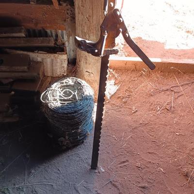 Fence stretcher tool with partial roll of barbed wire