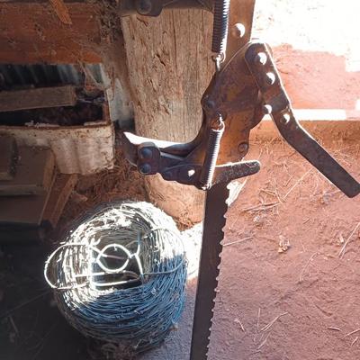 Fence stretcher tool with partial roll of barbed wire