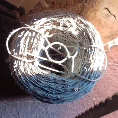 Fence stretcher tool with partial roll of barbed wire