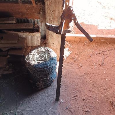 Fence stretcher tool with partial roll of barbed wire