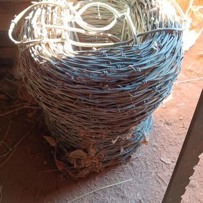 Fence stretcher tool with partial roll of barbed wire