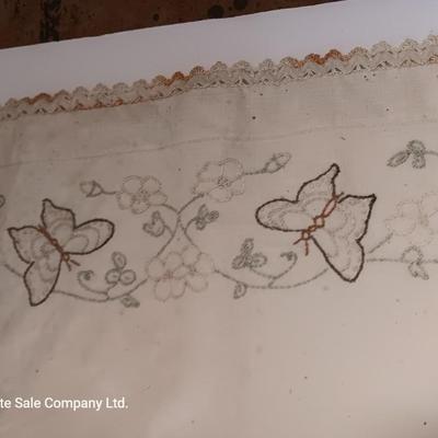 Four small brown crock bowls with embroidered linen