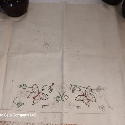 Four small brown crock bowls with embroidered linen