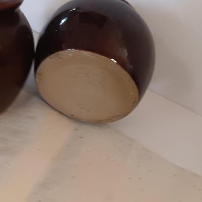 Four small brown crock bowls with embroidered linen