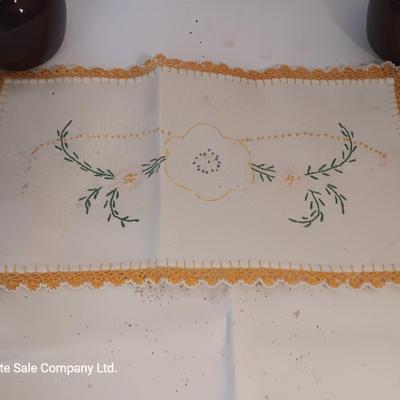 Four small brown crock bowls with embroidered linen