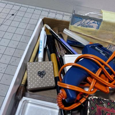 Crafting items: Stamp pad, Glue Gun and Paint Brushes. 