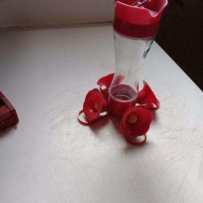 Wooden handmade bird feeder and a Glass globed hummingbird feeder.