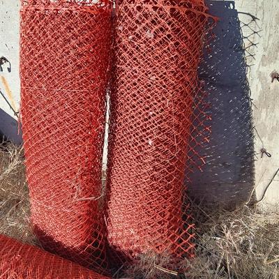 Four rolls of orange construction barrier fencing