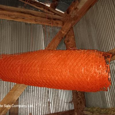 Four rolls of orange construction barrier fencing