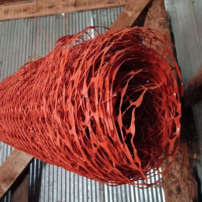 Four rolls of orange construction barrier fencing