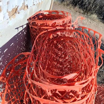 Four rolls of orange construction barrier fencing