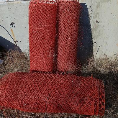Four rolls of orange construction barrier fencing