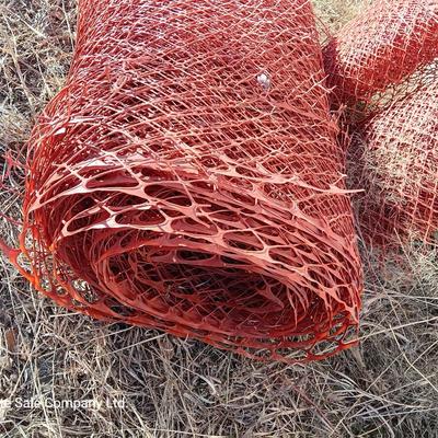Four rolls of orange construction barrier fencing