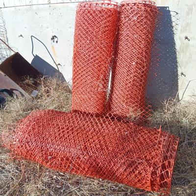 Four rolls of orange construction barrier fencing