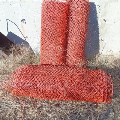 Four rolls of orange construction barrier fencing