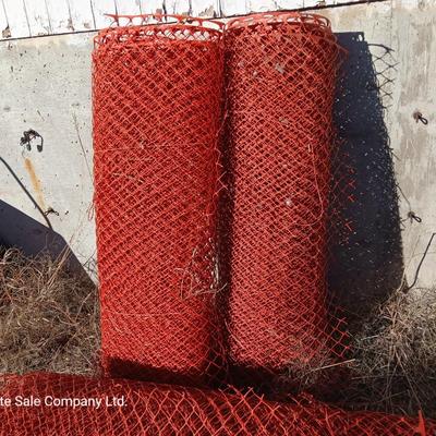 Four rolls of orange construction barrier fencing