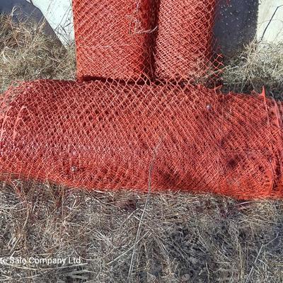Four rolls of orange construction barrier fencing