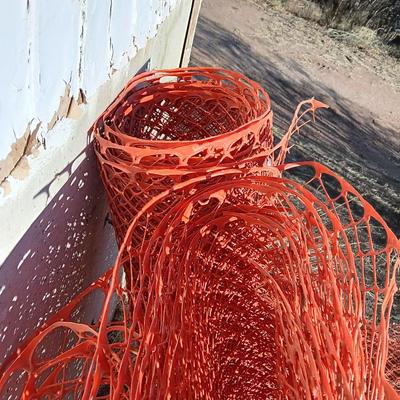 Four rolls of orange construction barrier fencing