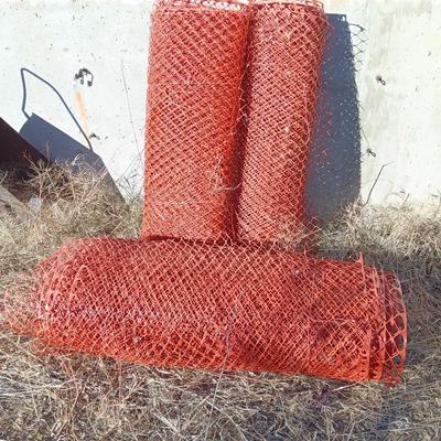 Four rolls of orange construction barrier fencing