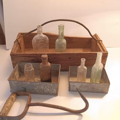 Antique wooden box with two metal boxes some old bottles and a vintage hay hook