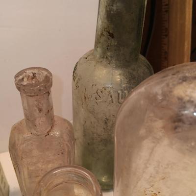 Antique wooden box with two metal boxes some old bottles and a vintage hay hook