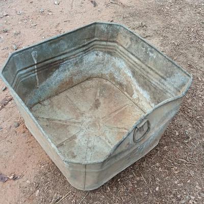 Metal wash tub with two vintage pickaxe heads