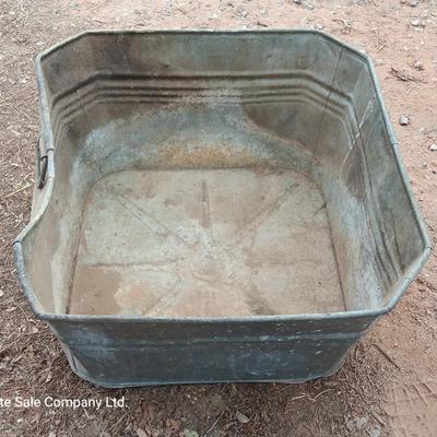 Metal wash tub with two vintage pickaxe heads